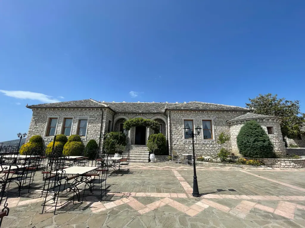 The stone restaurant building and terrace within Lëkurësi Castle on the hill above Saranda