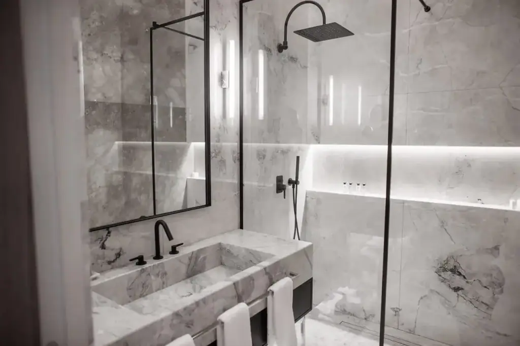 The grey marble bathroom of the Deluxe Suite with a walk-in shower