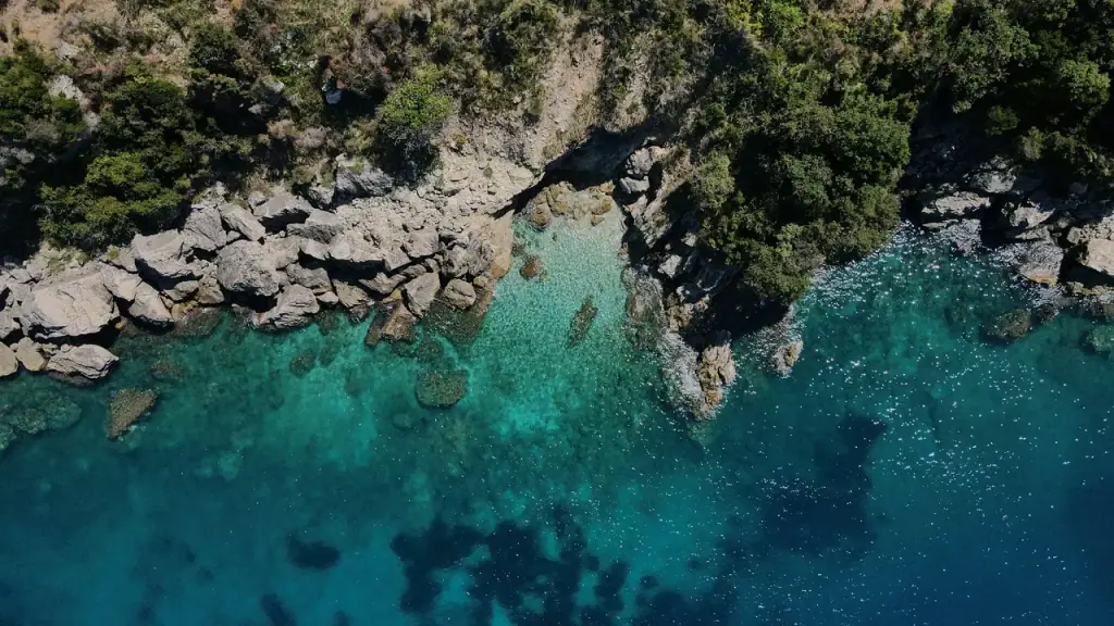 Clear turquoise Ionian water over pale rocks on the Himarë coast, seen from directly above