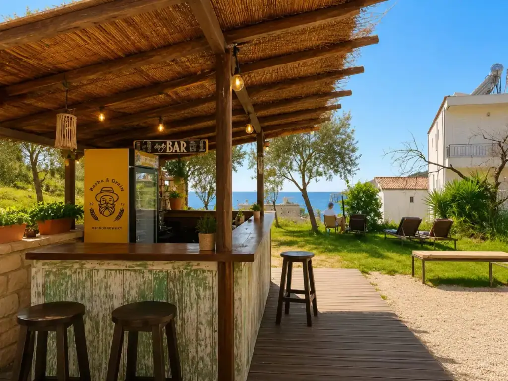 Bar stools along a timber counter beneath a reed canopy strung with bulbs, sea in the distance