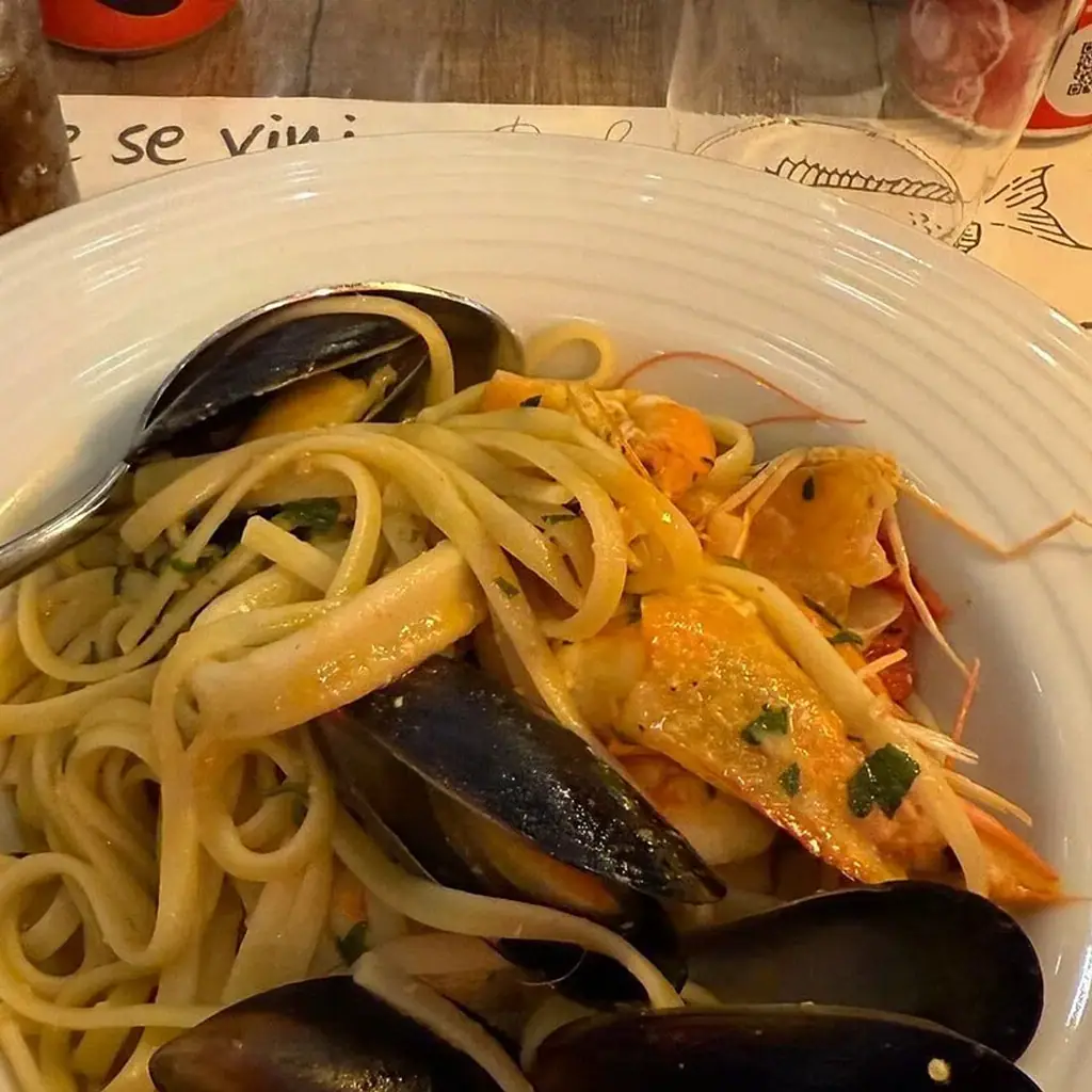 Linguine with mussels, two prawns and strips of squid, close