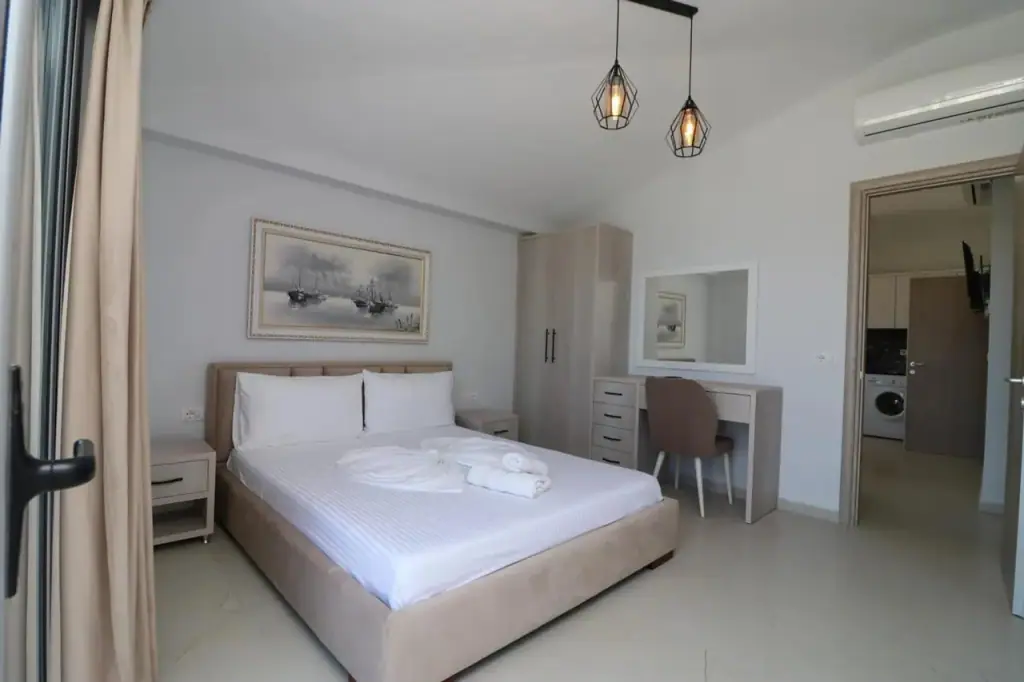 Apartment bedroom with a wide bed and a door onto the balcony