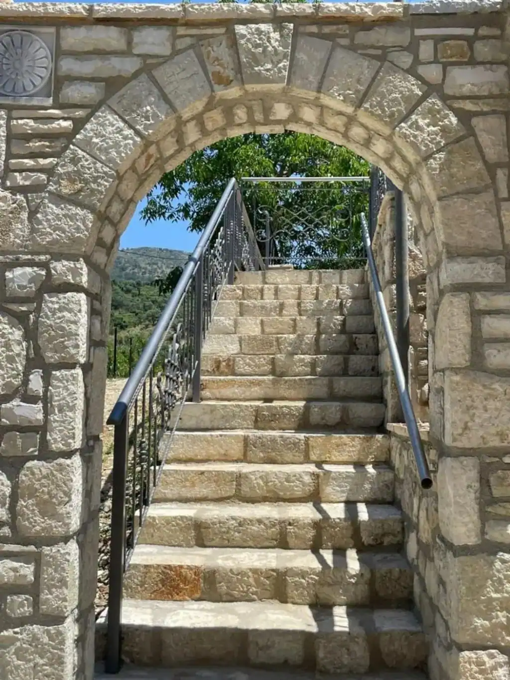 A limestone arch over the steps leading up into the garden