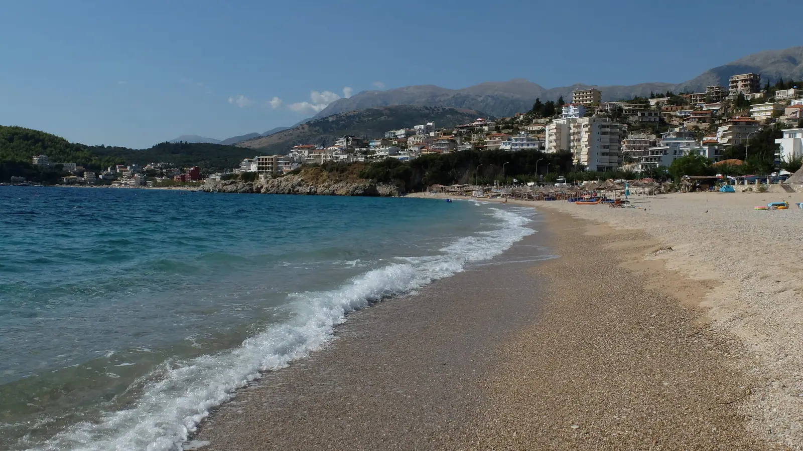 Spile beach at the waterline, the town and mountains rising behind it