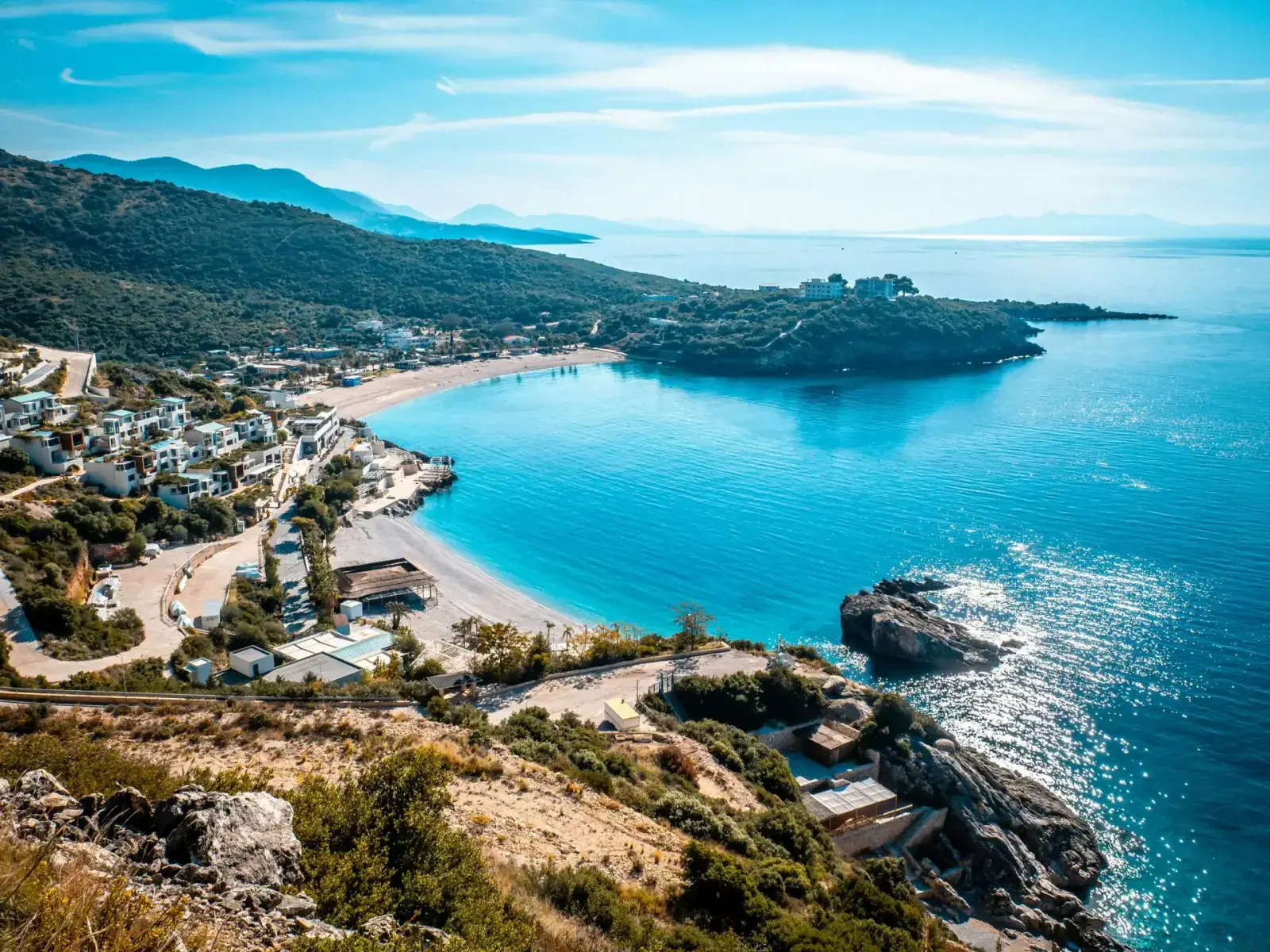Bunec Beach at sunset with turquoise water and pine-covered cliffs