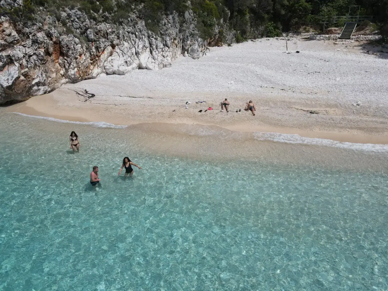 Aerial view of swimmers in the clear water off a Himara beach on the Albanian Riviera