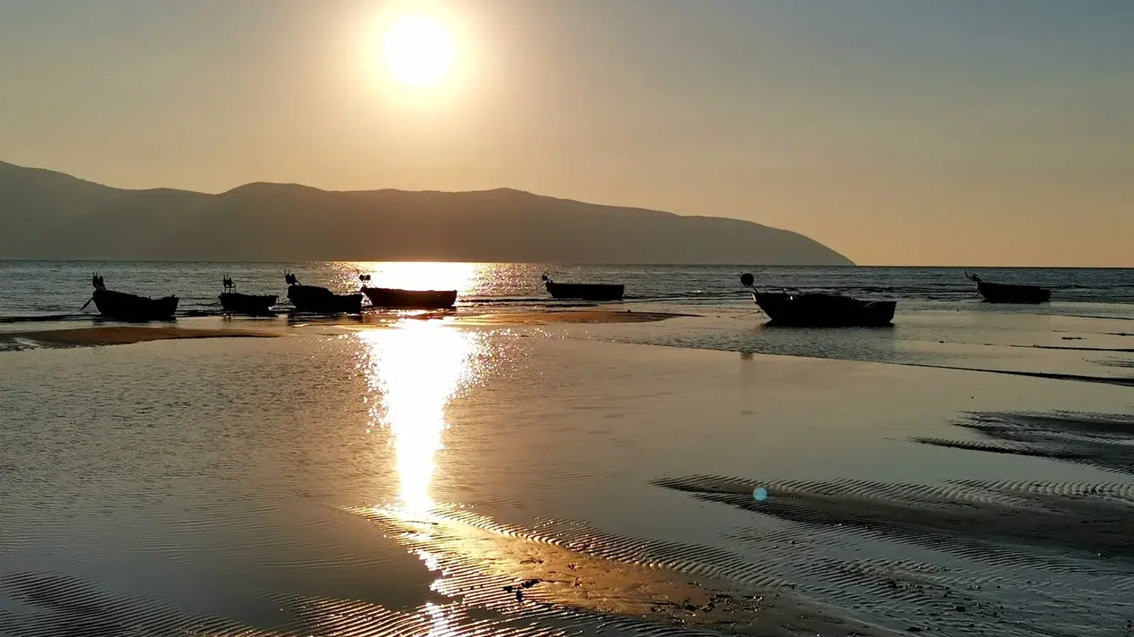 Early morning view of a quiet Himara beach with calm waters at sunrise