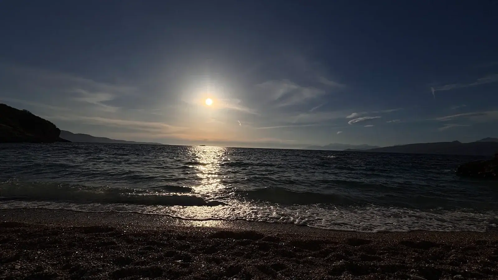 Ocean horizon with orange winter sunset sky near Himara