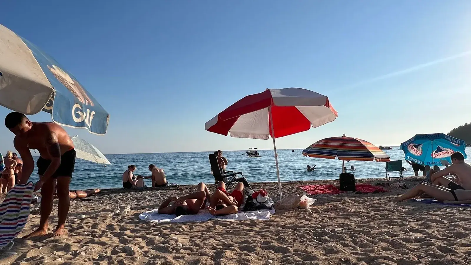 Summer beach umbrellas on Jale Beach near Himara during a sunny June day