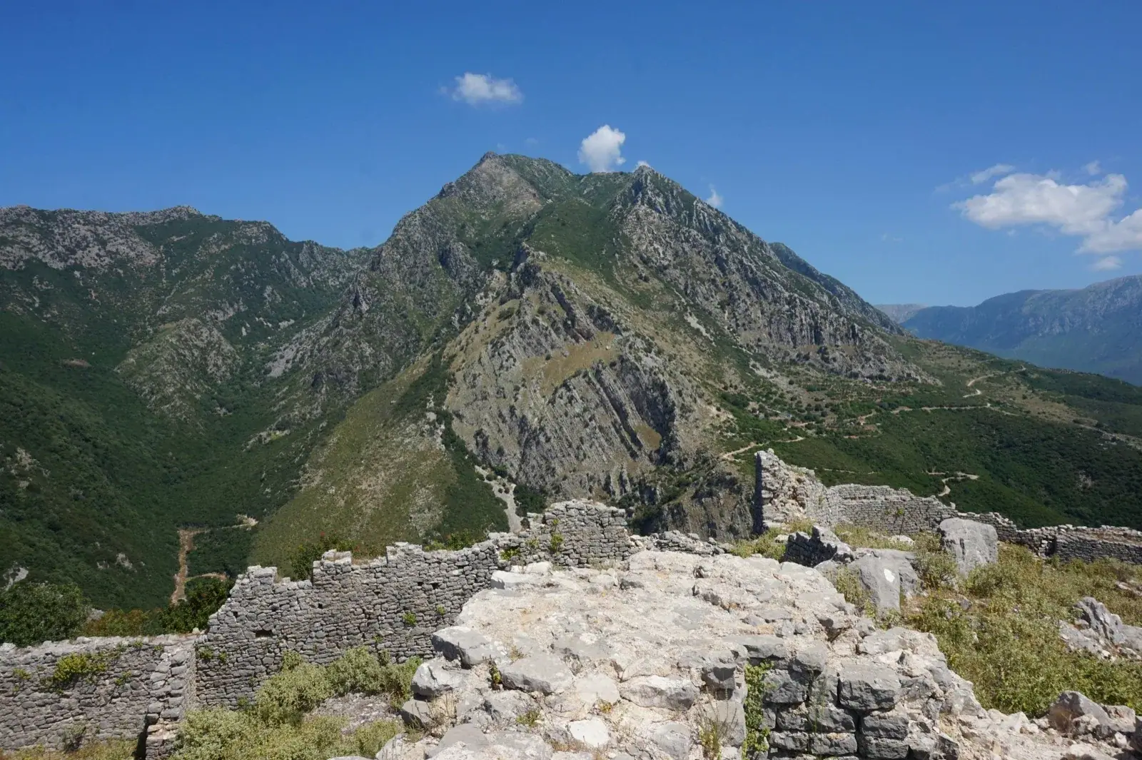 Mountain peak and castle ruins above Himara with Ceraunian Mountains