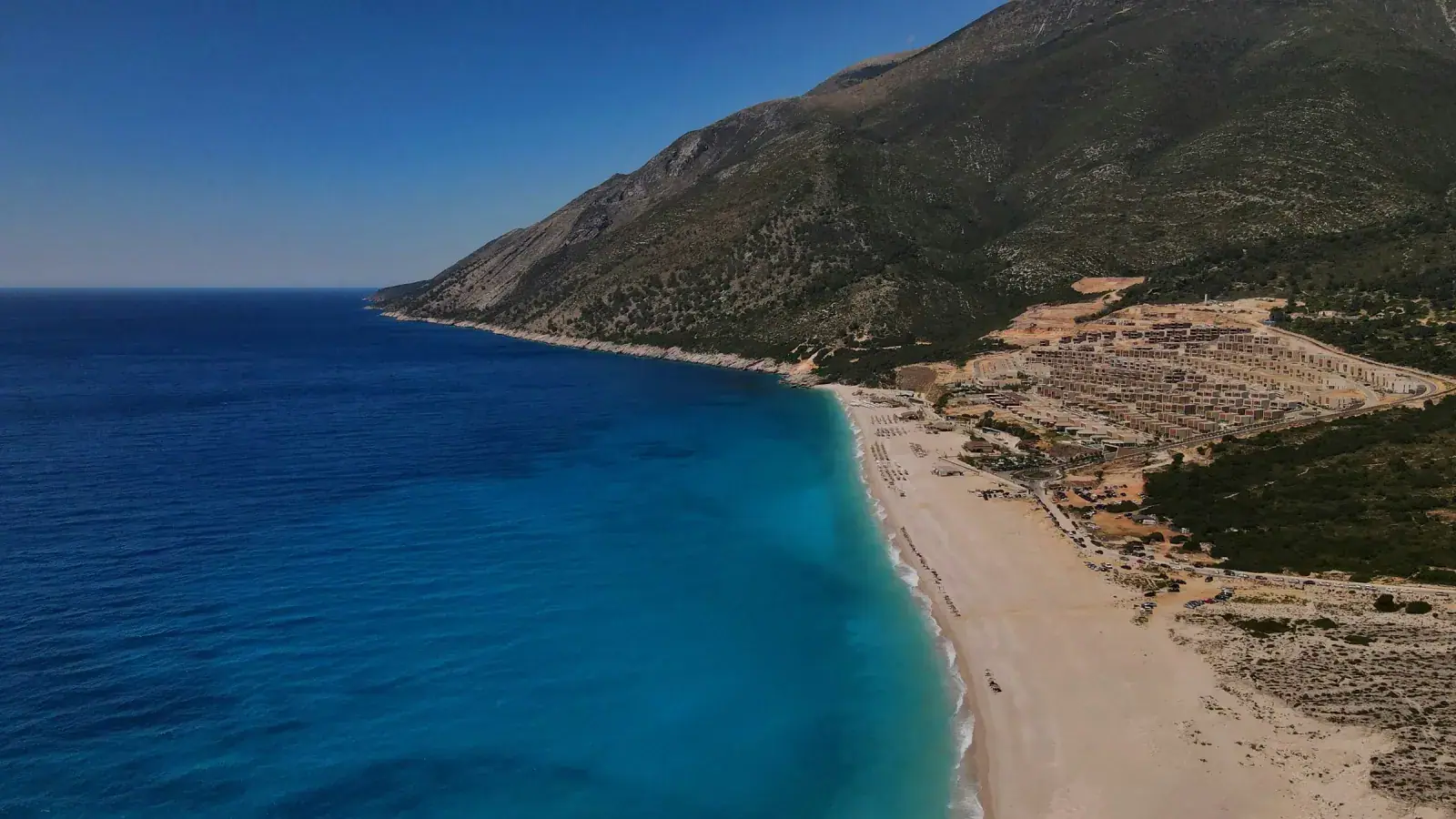 Aerial view of Livadhi Beach coastline showing nearby hotel zone