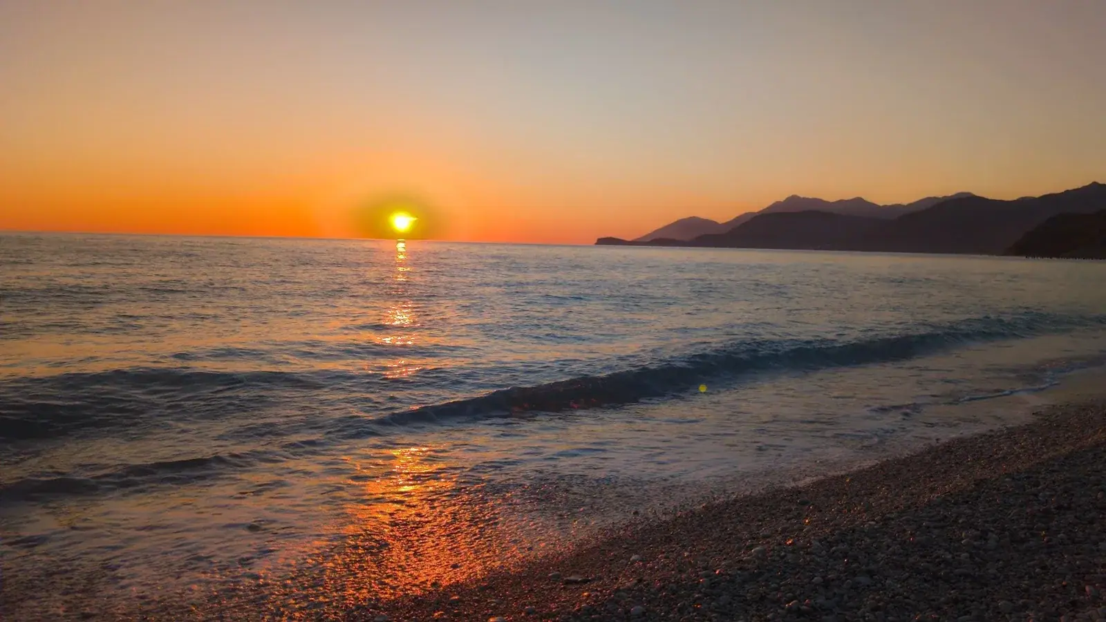 Albanian coastline at sunset where ride-hailing apps connect travelers across the Riviera