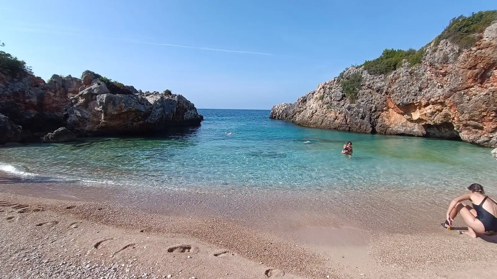 Pebble shore and clear turquoise water at Akuarium Beach