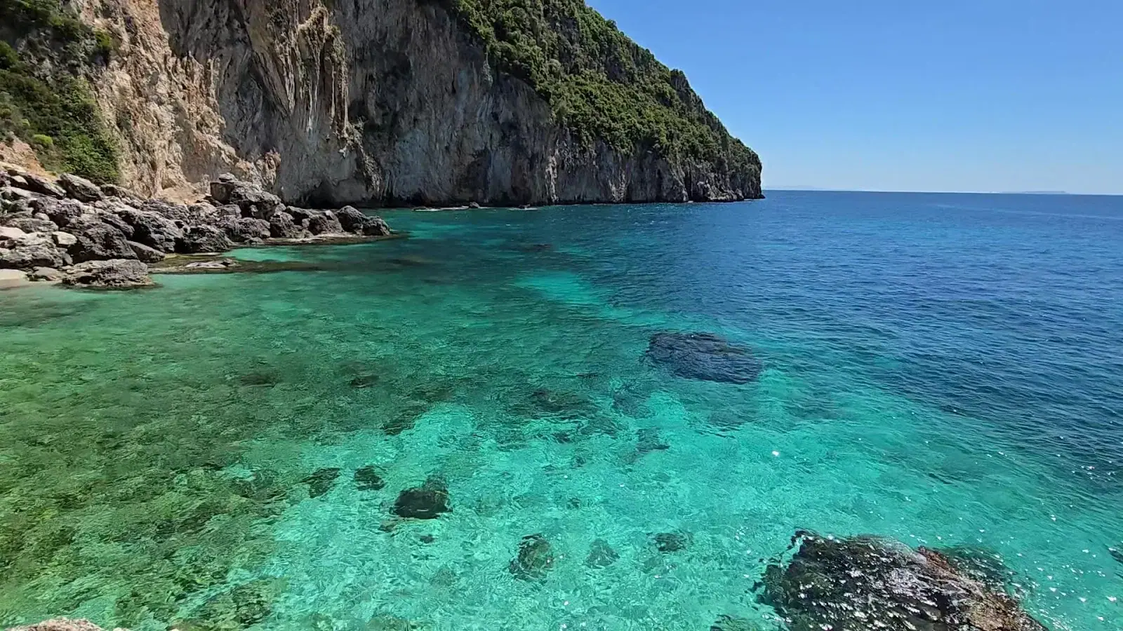 Turquoise water and submerged rocks off Alevra Beach