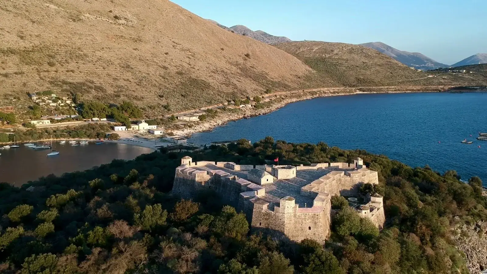 Porto Palermo castle from above with the bay and coast road behind