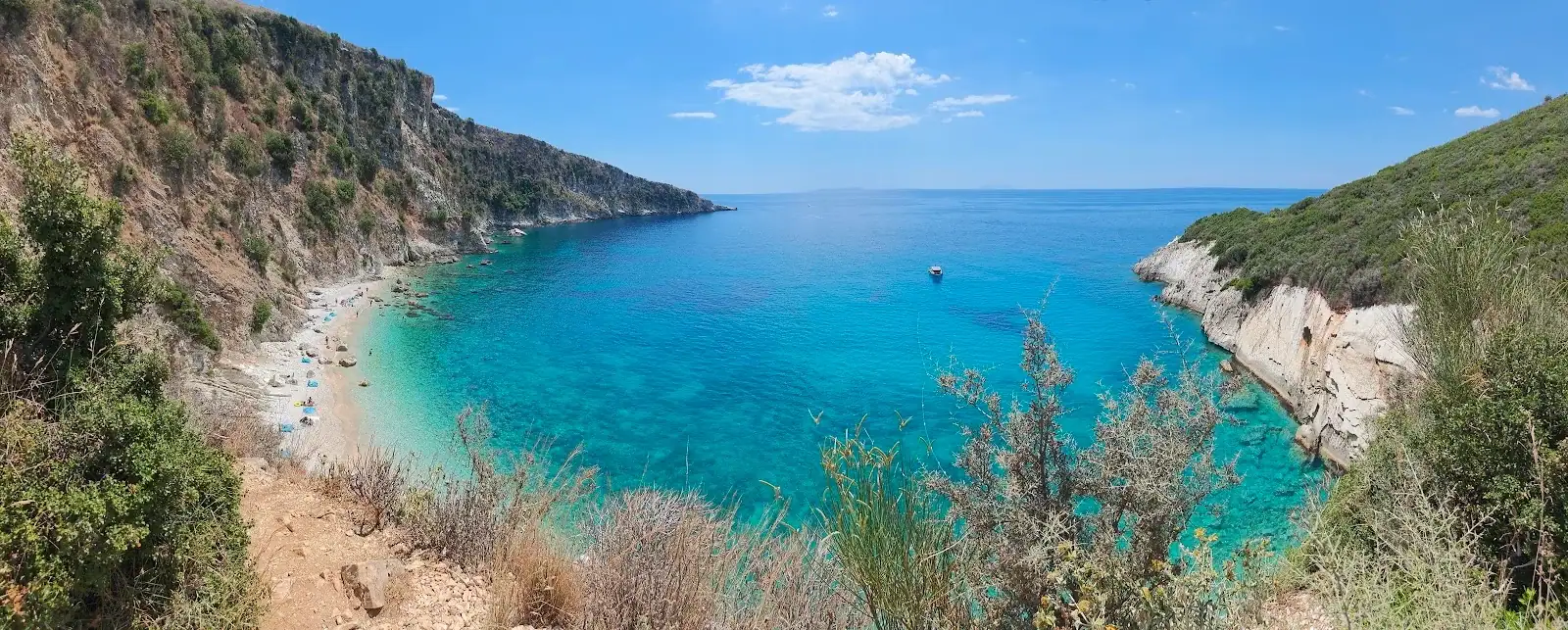 Filikuri bay from above, flat turquoise water against a limestone headland