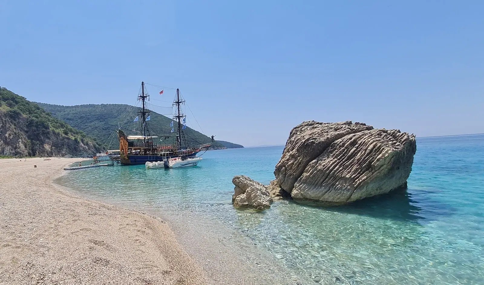 A wooden tour ship anchored off the rock at Krorez Beach