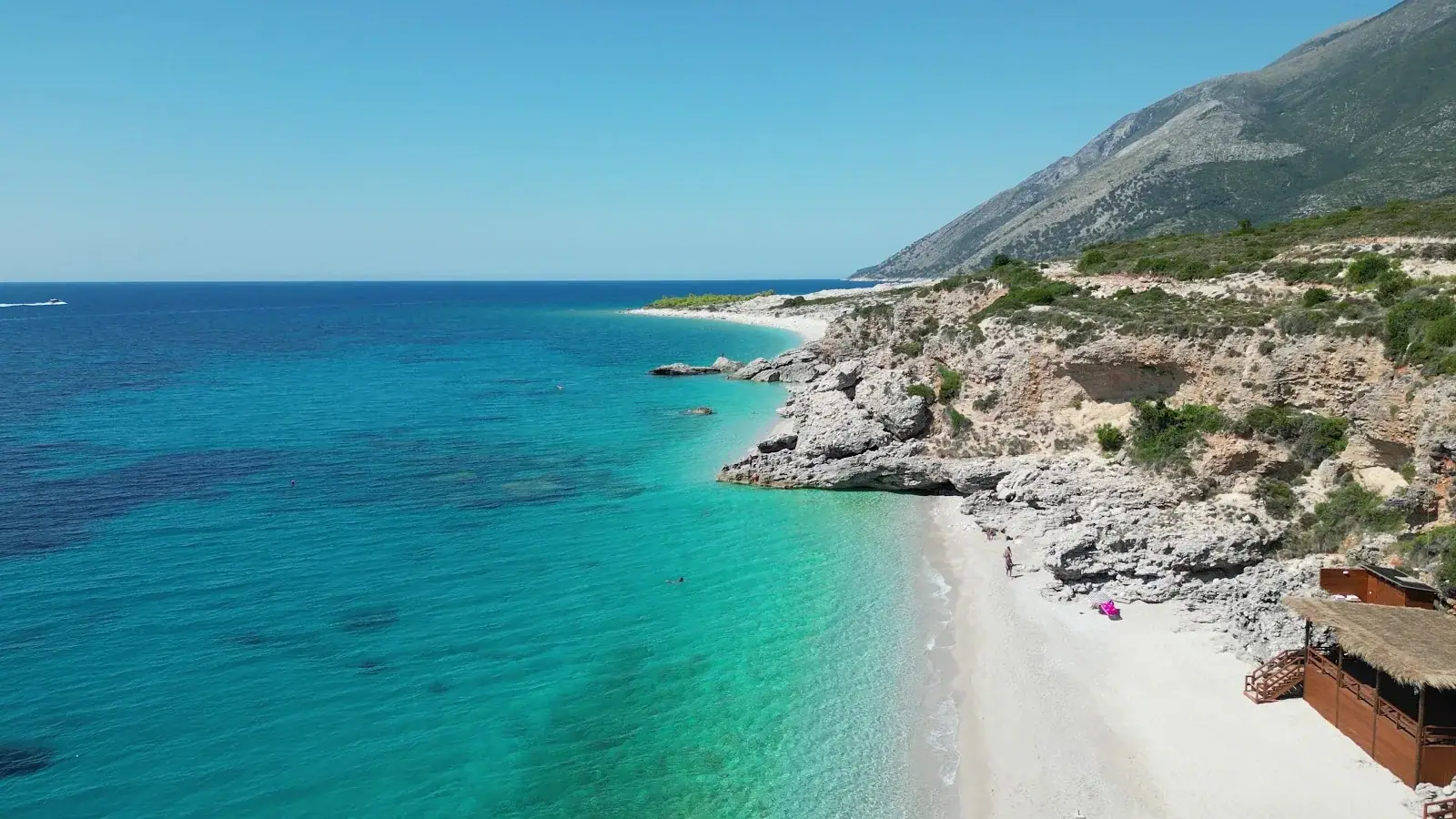 Aerial of Palasa's white pebble shore against turquoise water