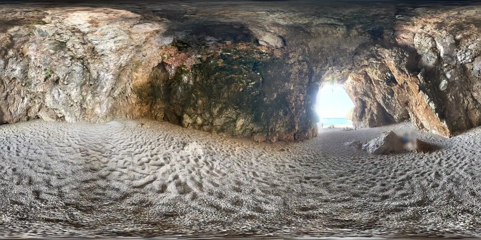 Inside Pigeon's Cave looking out to the bright water at its entrance
