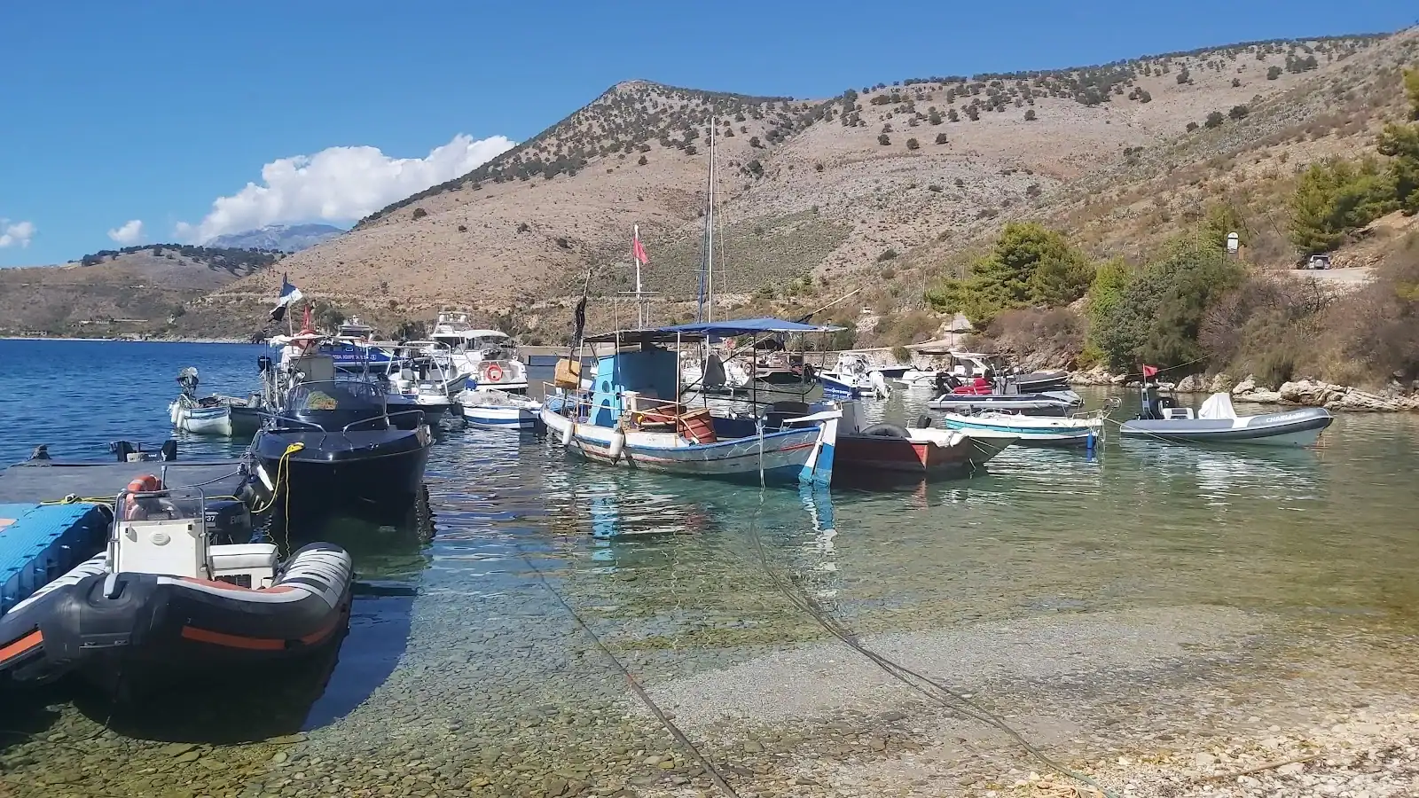 Fishing boats moored in the clear water of Porto Palermo bay