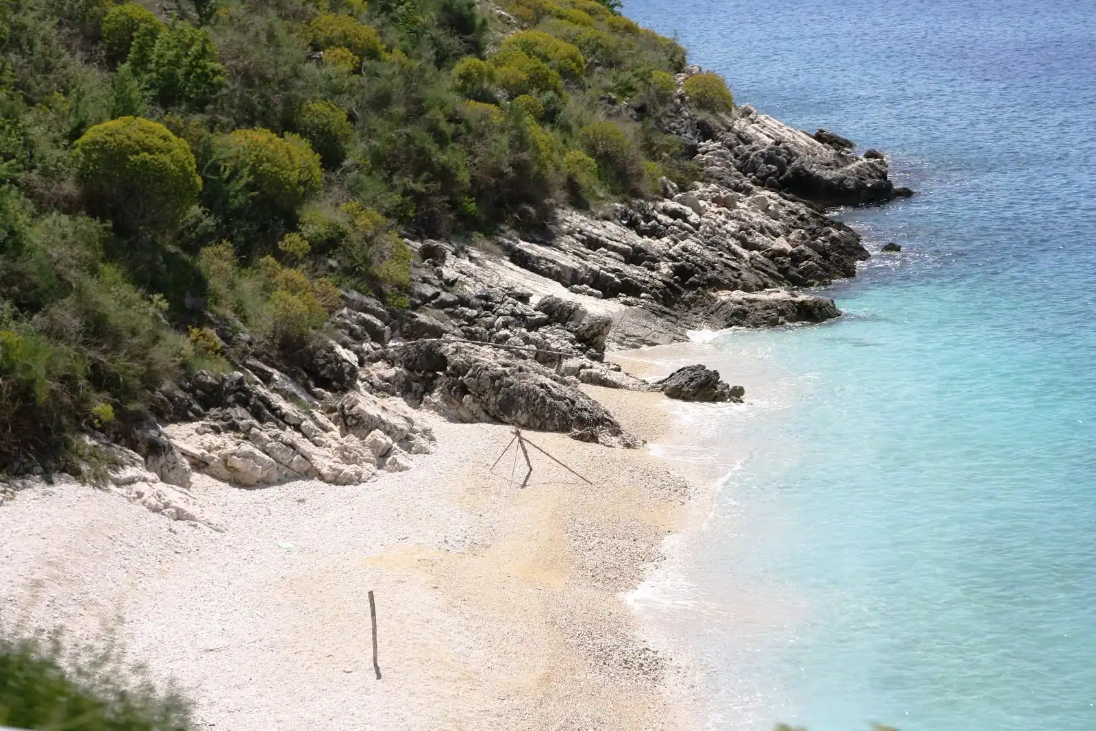 White pebbles and clear water at the Porto Palermo shoreline