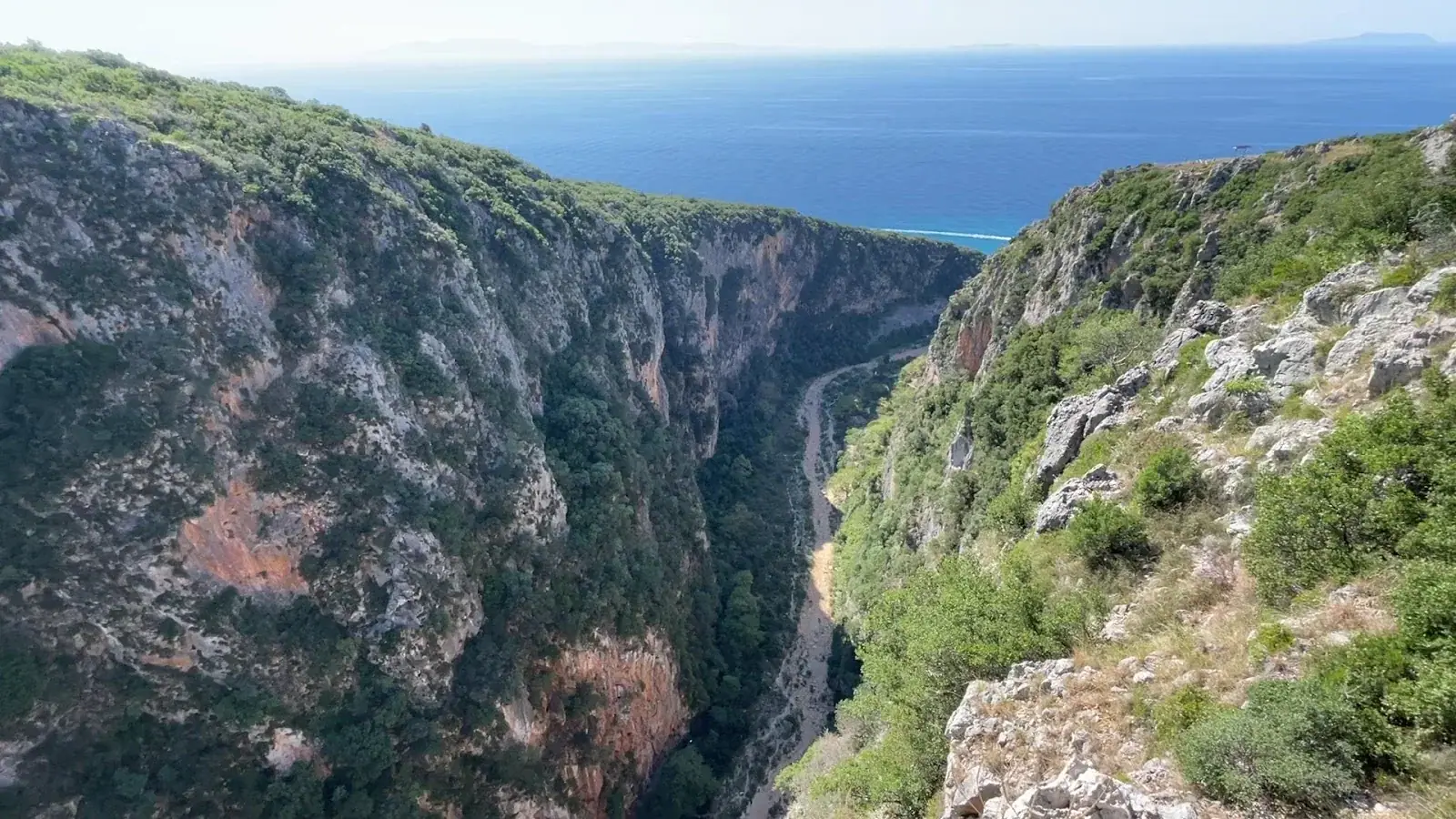 Old arched stone bridge spanning a clear stream in the Gjipe Canyon on the Albanian Riviera