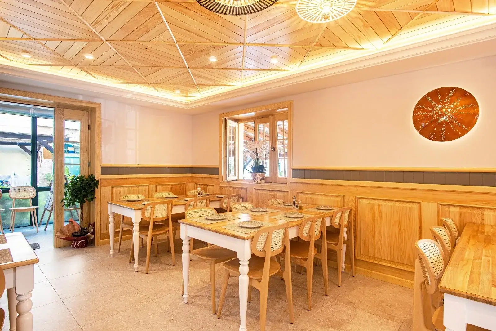 Warm wood-panelled dining room with set tables at Taverna Lefteri in Himara