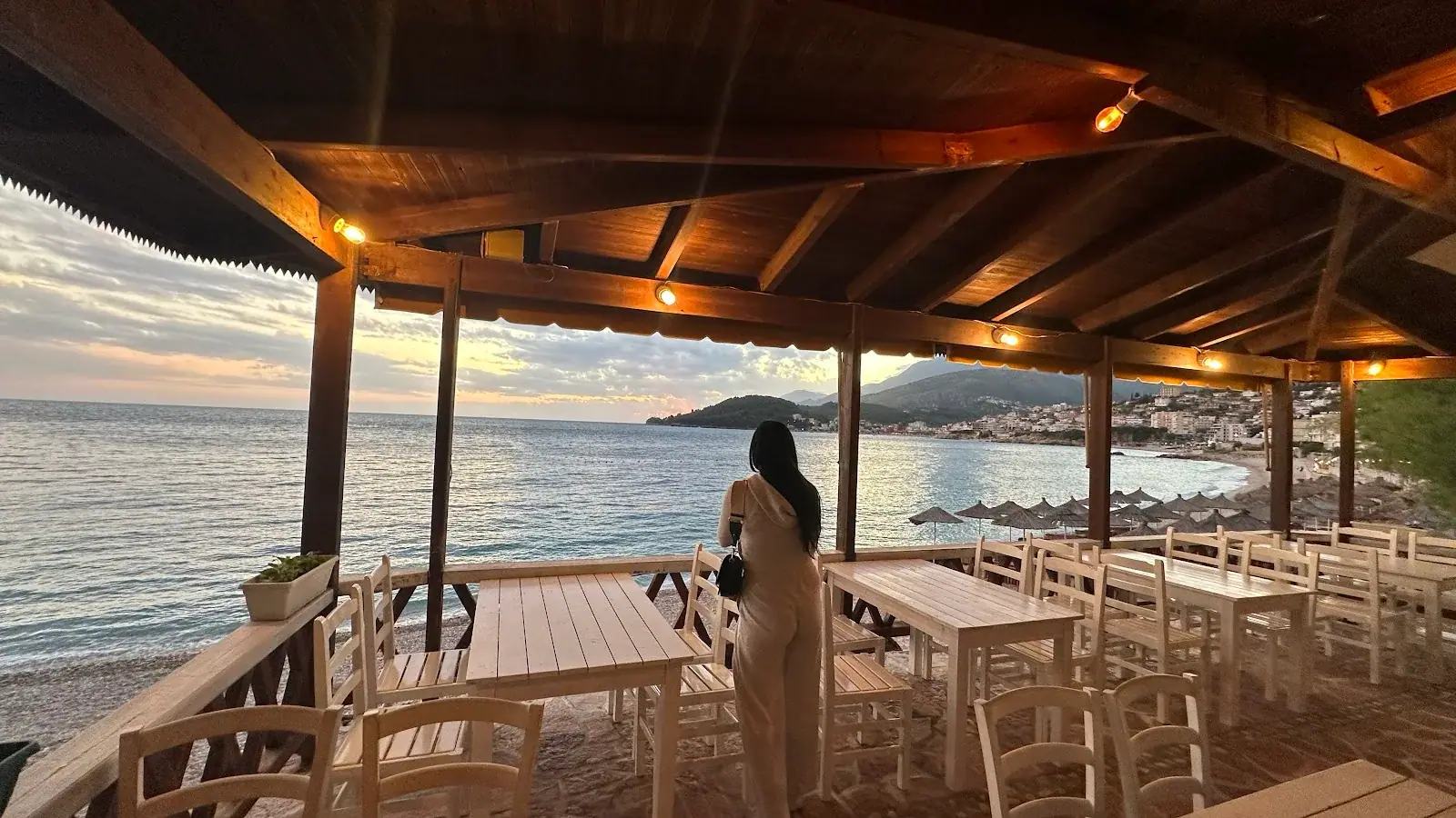 Wooden beachfront pergola with set tables at sunset at Lui Potam on Potam Beach in Himara