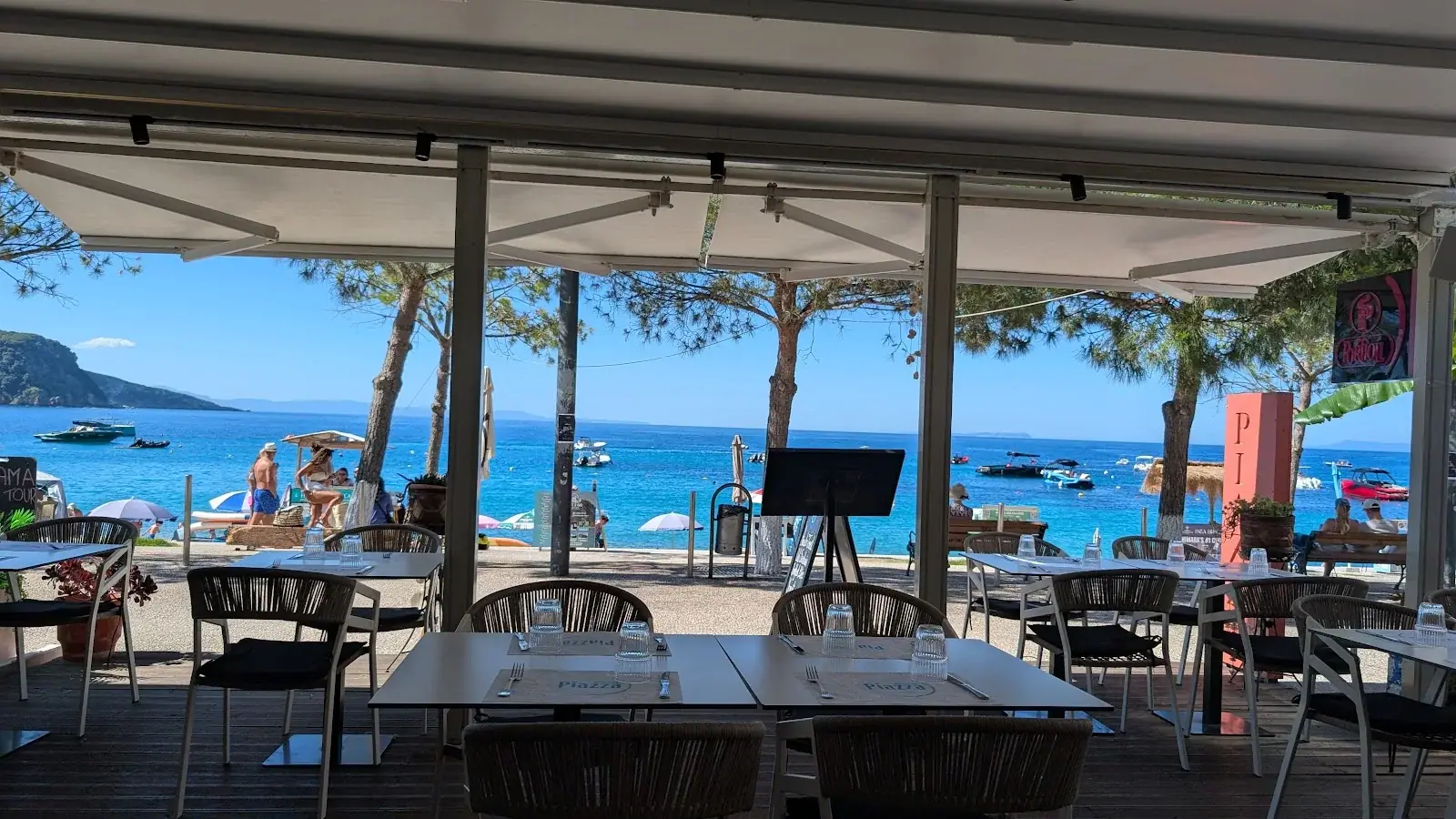 Seafront dining terrace with set tables overlooking the bay at Piazza Restaurant in Himara
