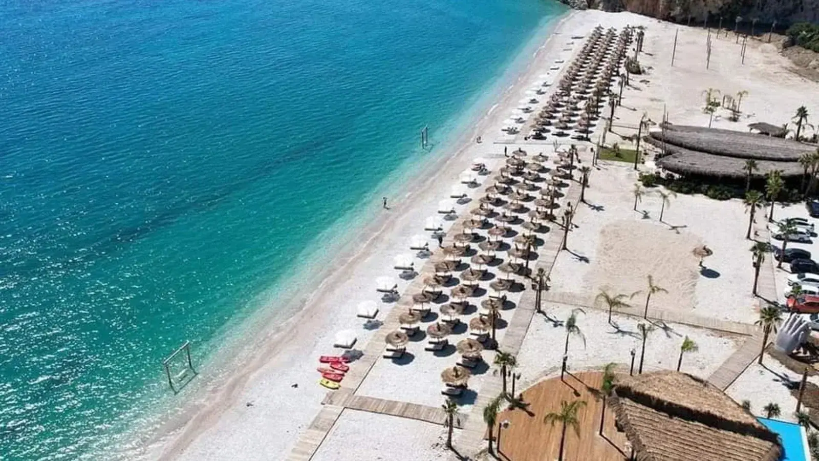 The long pebble sweep of Borsh beach backed by olive groves and hills