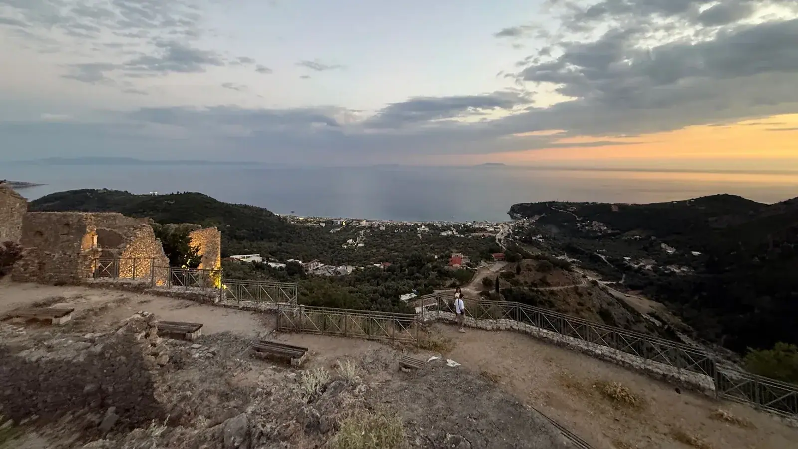 Himara castle terrace at dusk, looking down over the lit town and the bay