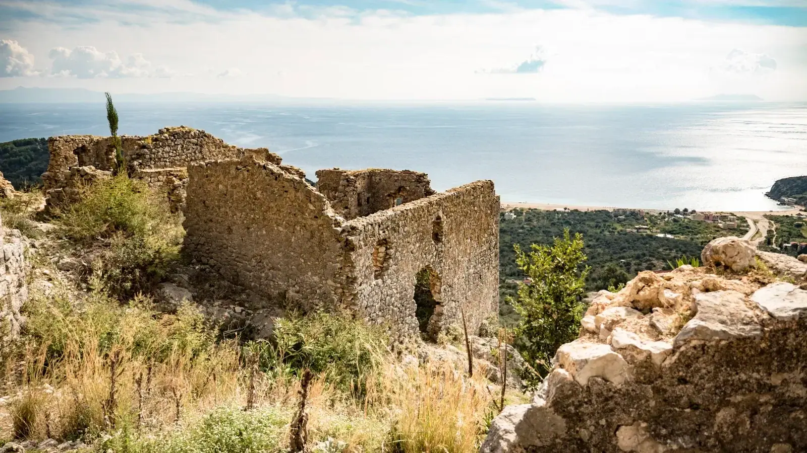 The stone ruins of Himara's old town on the ridge above the coast, with the Ionian Sea beyond