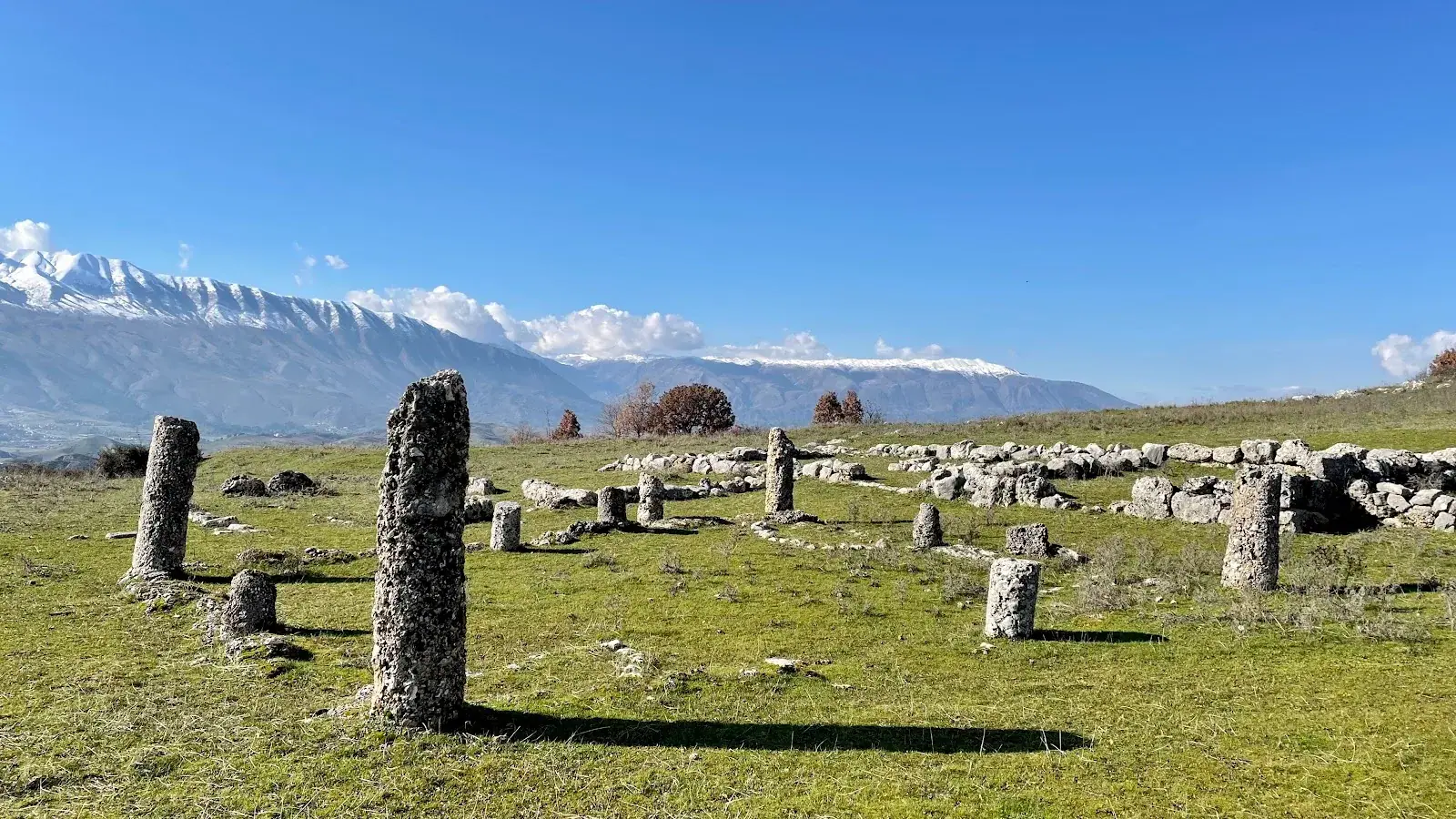 Ancient stone foundations of Antigonea on a hilltop overlooking the green Drino valley near Gjirokastër