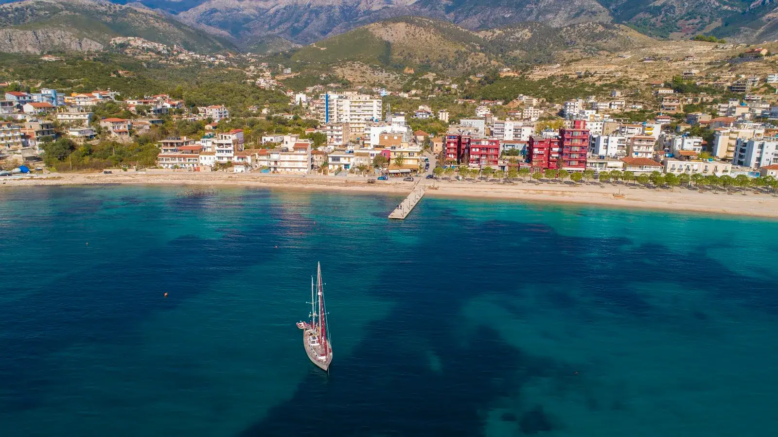 Steinwellenbrecher und Fischerboote am Himara Mini Dock
