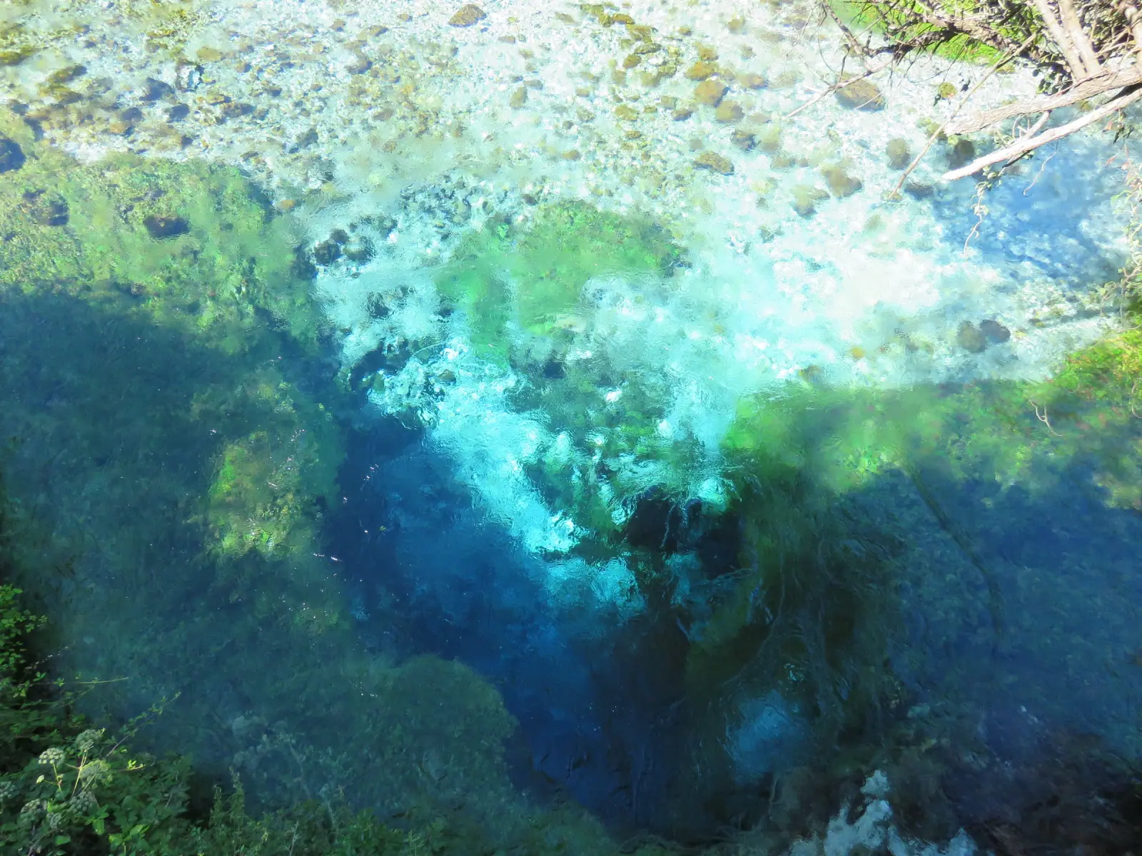 The Blue Eye spring, deep blue water rising through pale karst rock