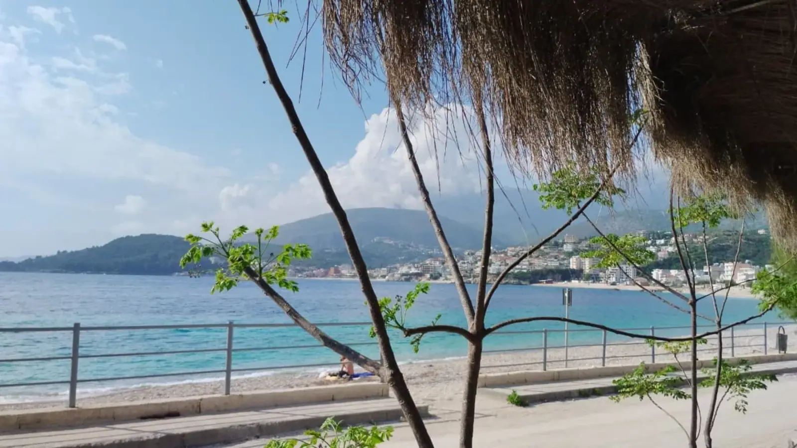 The view from under the thatch along Potam beach to Himarë town on the far side of the bay
