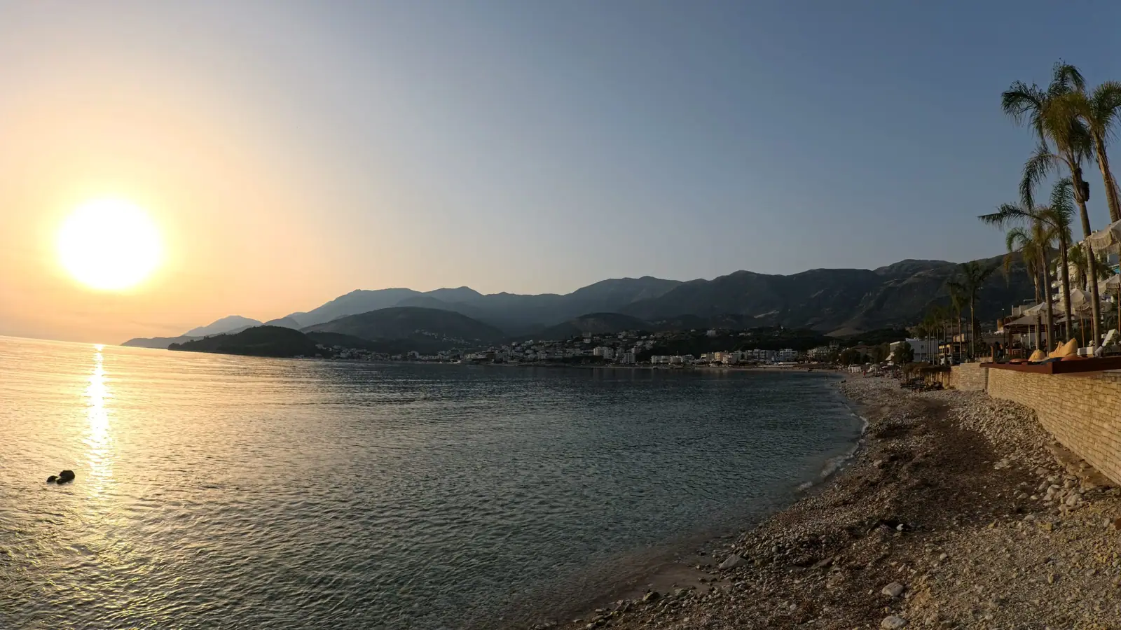 The sun setting over Potami beach and the bay of Himarë, with the Ceraunian mountains behind