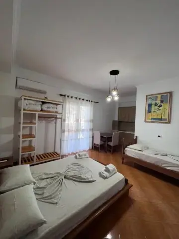 Triple Room: the bed, a second single bed, the open shelf unit and the dining table