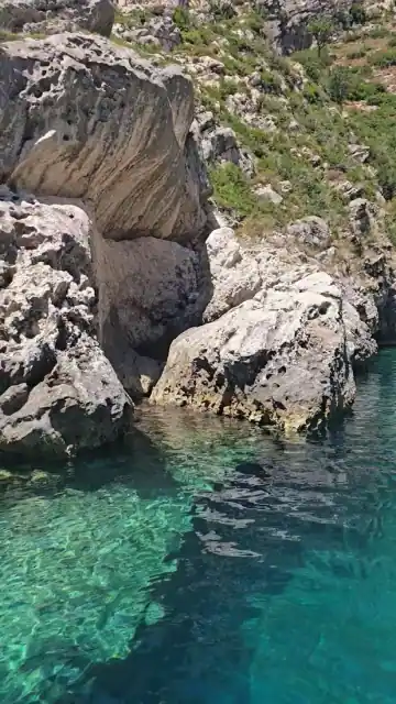 Rocks and green water at the entrance to Bats Cave