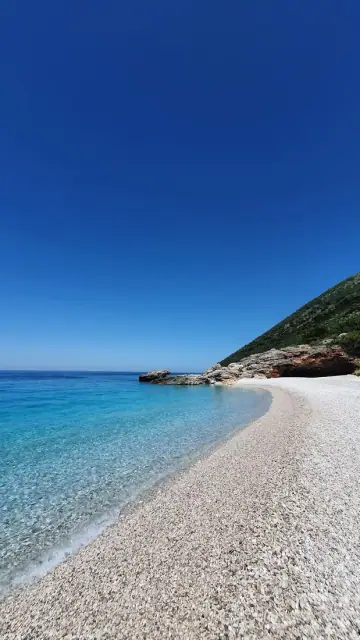 The white pebble strand at Palasa meeting deep blue water