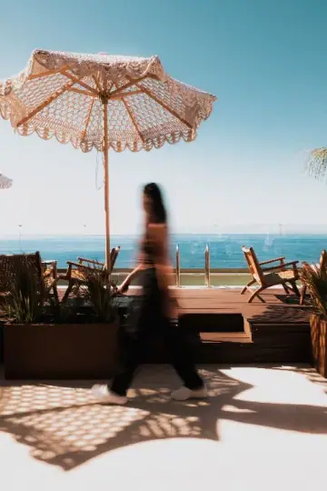 The roof deck at noon, parasol shadows across the boards