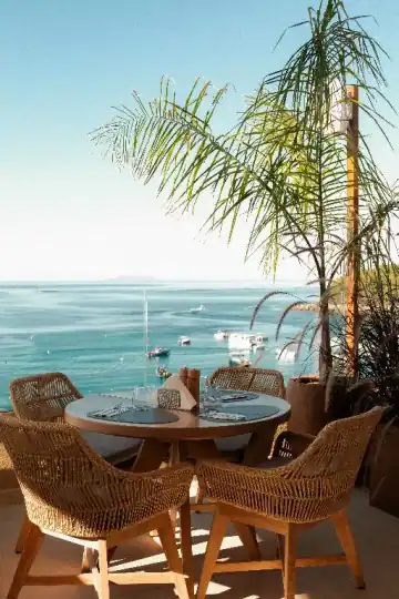 A table for two on the roof with the bay and the palms behind