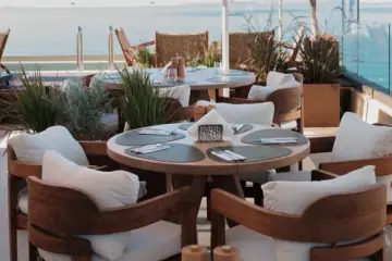 Round tables and cushioned chairs on the roof in the morning