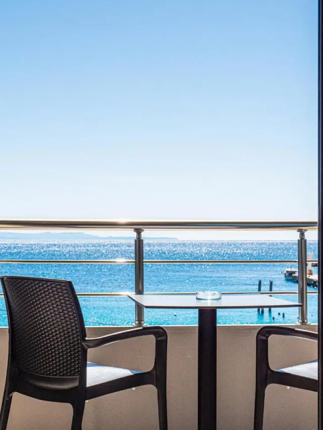 The open Ionian seen from a balcony table at Endless Blue Himara, with the far shore on the horizon