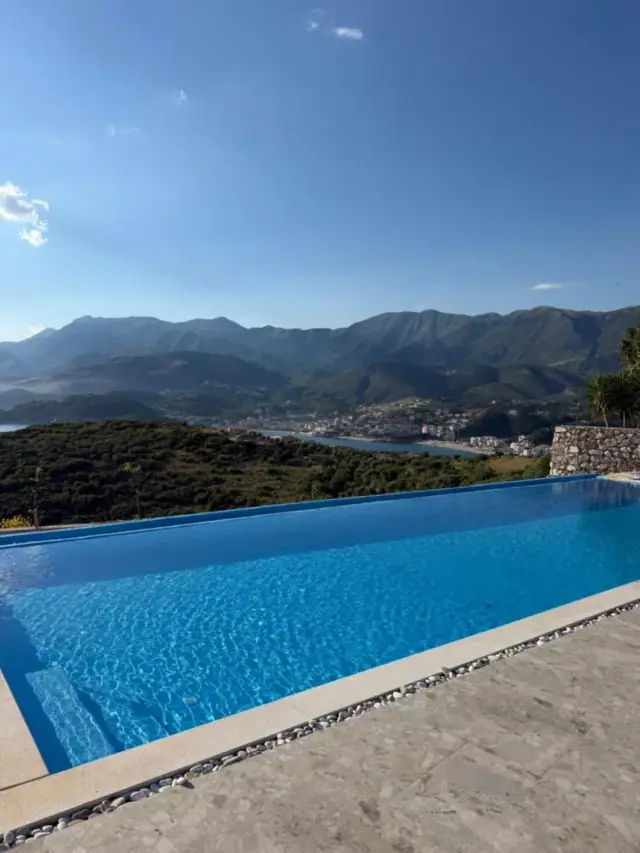 The infinity pool at Filikuri Boutique Hotel, its far edge level with Himarë on its bay and the Ceraunian mountains beyond
