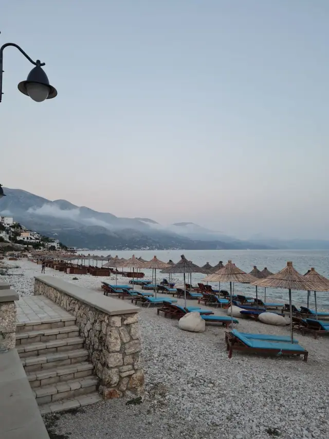 Paseo empedrado de Qeparo Beach con farolas de estilo antiguo