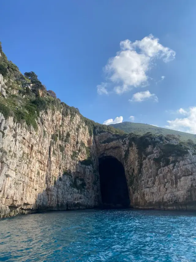 The Blue Cave entrance in the cliff face above the sea