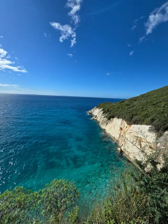 Steep white cliffs dropping into deep blue water at Filikuri