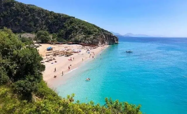 Gjipe Beach with turquoise shallows and the canyon mouth behind