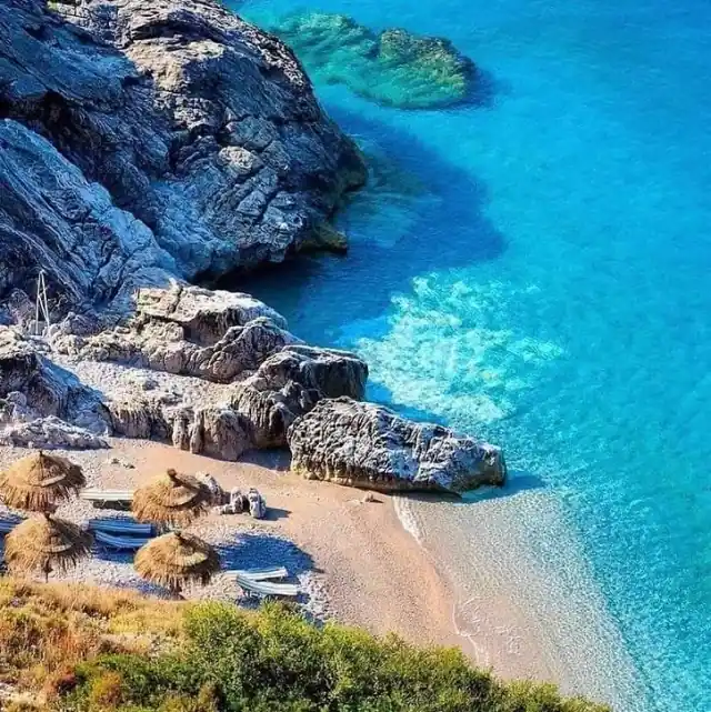 Rocks and bright turquoise shallows at the edge of Jale Beach